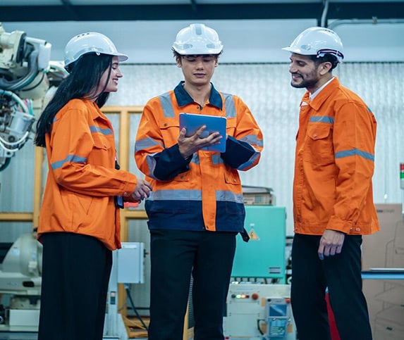 Manufacturing professionals in hard hats having a discussion