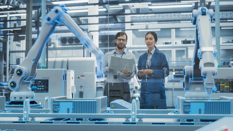 Manufacturing professionals implement and test a robot on a production line