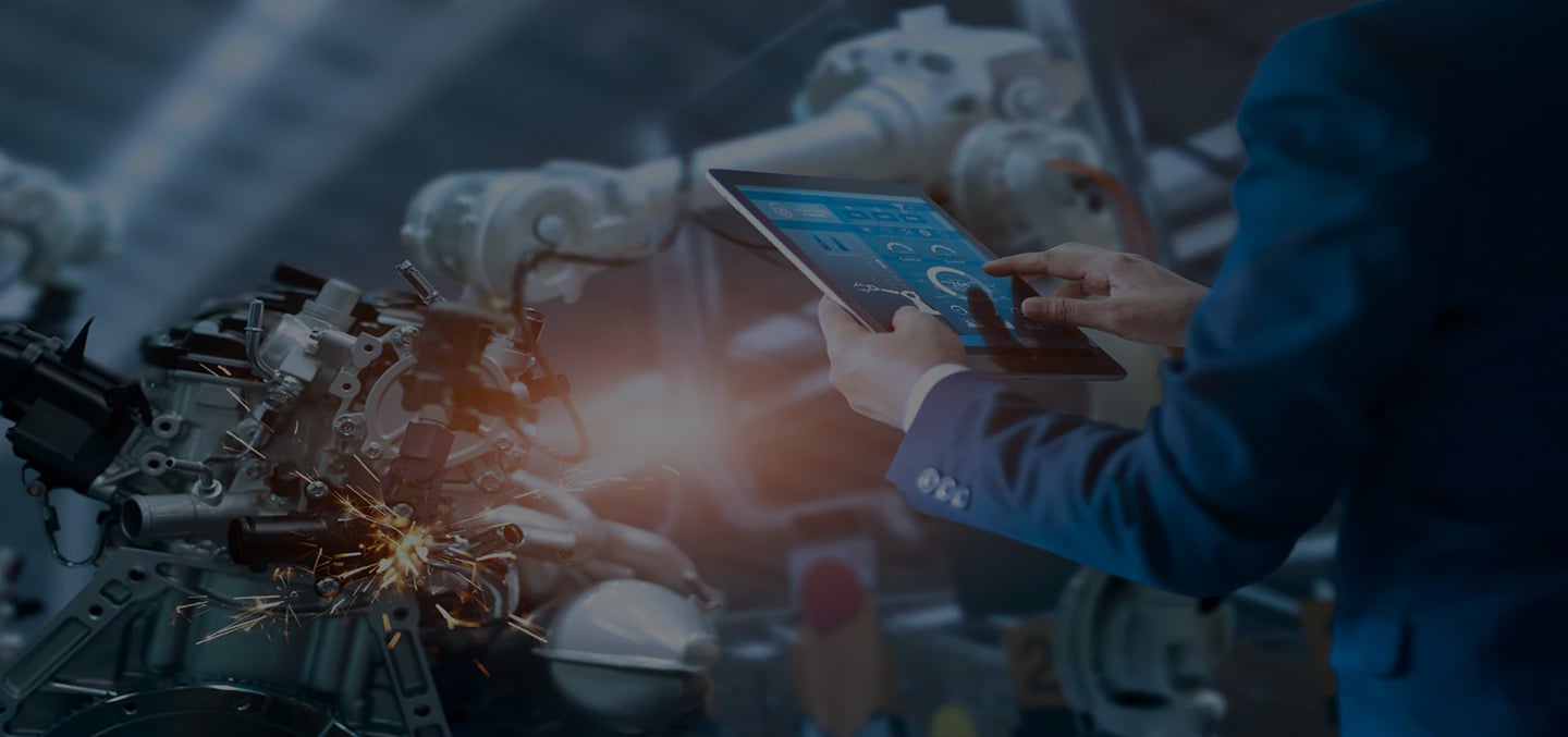 Engineer holding a tablet testing a robot